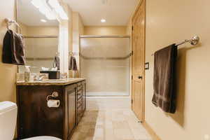 Full bathroom featuring vanity, enclosed tub / shower combo, and tile patterned flooring