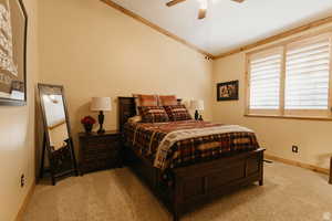 Bedroom featuring carpet flooring, ceiling fan, and ornamental molding