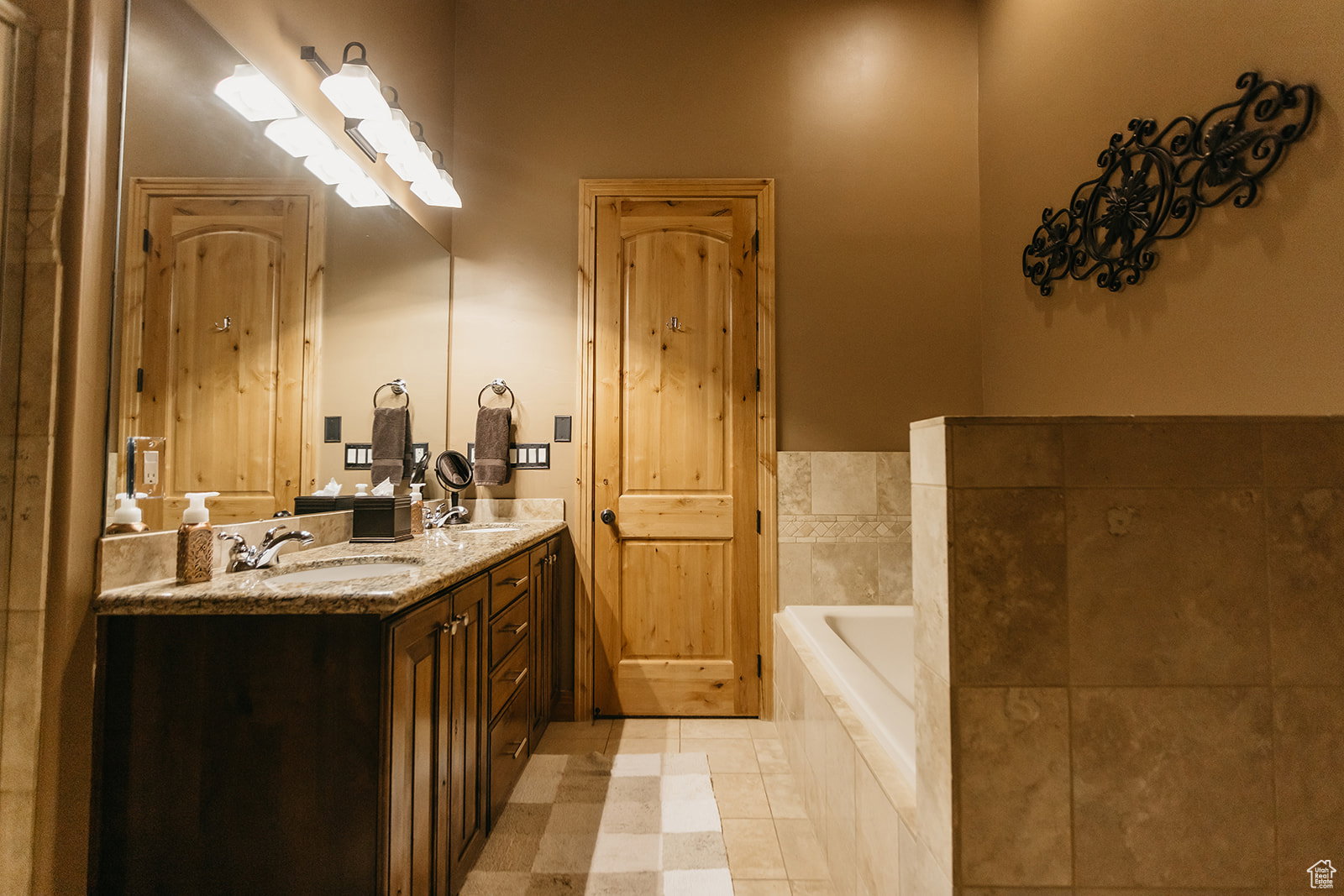 Bathroom with double vanity, a bath, and tile patterned floors