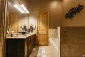 Bathroom with double vanity, a bath, and tile patterned floors
