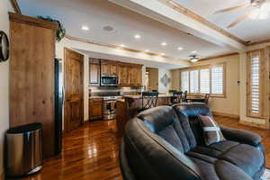 Living area featuring crown molding, ceiling fan, dark wood-style floors, and recessed lighting
