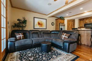 Living area featuring wood finished floors, ornamental molding, and recessed lighting
