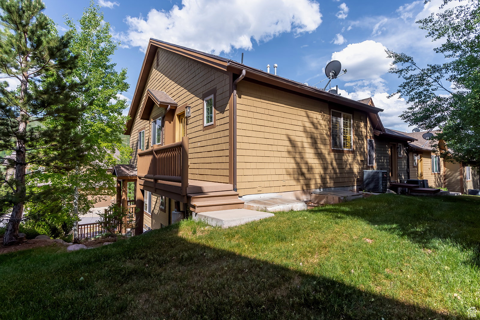 View of side of home featuring a lawn and a central air condition unit