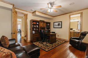 Office area featuring dark wood-style flooring, a ceiling fan, and ornamental molding