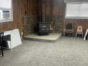 Living area featuring wood walls, a wood stove, and cooling unit