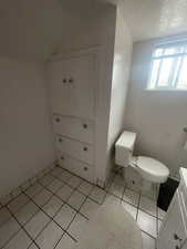 Bathroom featuring tile patterned flooring and a textured ceiling