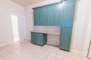 Kitchen with built in study area, light countertops, and light tile patterned floors