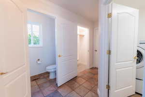 Bathroom featuring stone finish flooring and washer / dryer