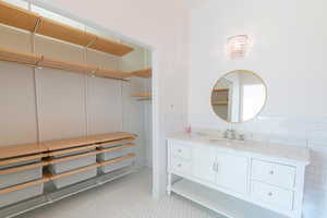 Bathroom with vanity, tile patterned floors, and wainscoting