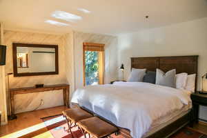 Bedroom featuring wood finished floors and wood walls