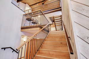 Staircase featuring a towering ceiling and a ceiling fan