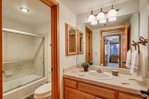 Bathroom with vanity and shower / bath combination with glass door
