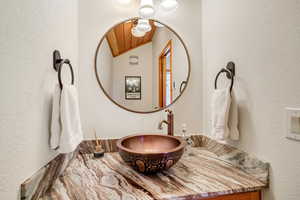 Bathroom with vaulted ceiling and a textured wall