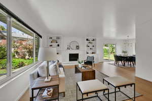 Living area featuring wood finished floors, a chandelier, and a fireplace
