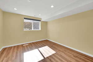 Unfurnished room with wood finished floors, recessed lighting, and a textured ceiling