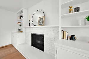 Unfurnished living room featuring light wood-type flooring, a fireplace, and built in features