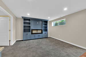 Unfurnished living room featuring recessed lighting and dark carpet