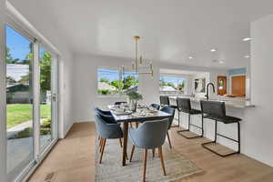 Dining area featuring light wood-type flooring, recessed lighting, and a chandelier