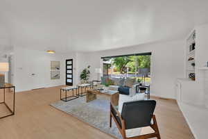 Living area with light wood finished floors and built in shelves