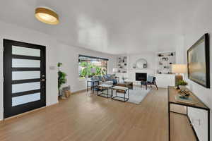 Living room with light wood-type flooring and a fireplace