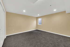 Spare room with recessed lighting and dark carpet