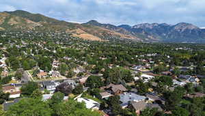 Aerial overview of property's location with a mountain backdrop and nearby suburban area