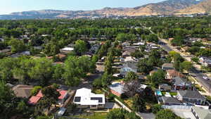 Aerial view of property and surrounding area featuring a mountain backdrop and nearby suburban area