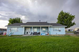 Back of house featuring roof with shingles and a patio