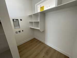 Laundry area with wood finished floors and hookup for a washing machine