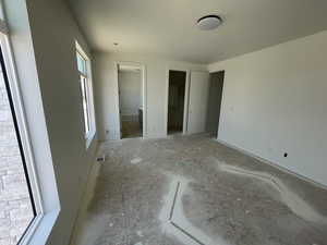 Unfurnished bedroom featuring a spacious closet and ensuite bathroom