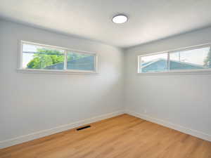 Spare room featuring light wood finished floors and a textured ceiling