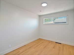 Spare room with baseboards and light wood-style flooring