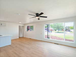 Unfurnished living room featuring light wood-style flooring and ceiling fan