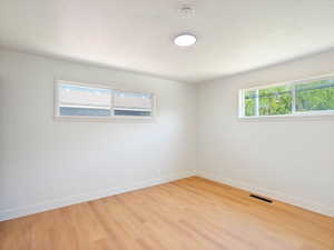 Empty room featuring baseboards and light wood-style flooring