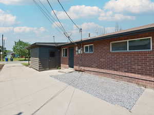 Back of house with brick siding and a patio