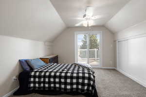 Bedroom with access to exterior, lofted ceiling, carpet flooring, and ceiling fan