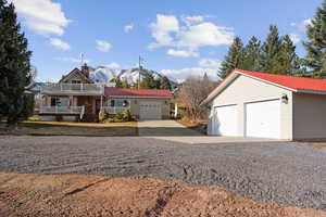 View of front of home featuring a porch, a metal roof, a mountain view, and a garage