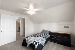 Bedroom featuring carpet flooring, vaulted ceiling, and ceiling fan