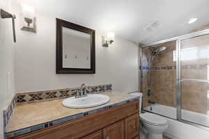 Full bath featuring vanity and combined bath / shower with glass door