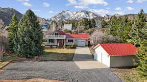 View of front of property with a porch, a mountain view, a metal roof, and driveway