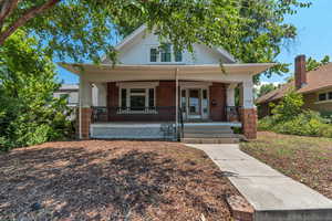 Bungalow-style home featuring brick siding and a porch