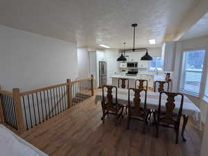 Dining area with wood finished floors and a textured ceiling