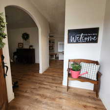 Corridor with arched walkways and wood finished floors