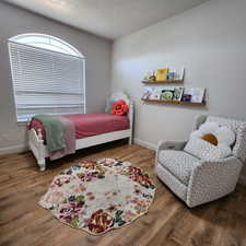 Bedroom with wood finished floors and baseboards