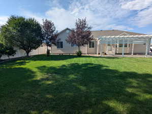 Rear view of property with a pergola, a patio, and a shingled roof