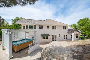Rear view of house with a tiled roof and stucco siding