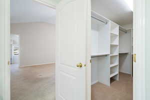 Spacious closet with carpet and lofted ceiling