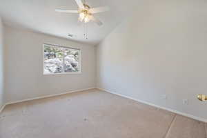 Unfurnished room featuring light carpet, vaulted ceiling, and ceiling fan