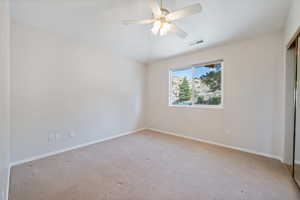 Unfurnished bedroom featuring carpet floors, a closet, and a ceiling fan