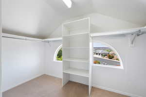 Walk in closet featuring vaulted ceiling and carpet floors